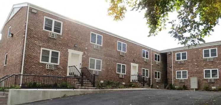 a red brick building with stairs and a parking lot