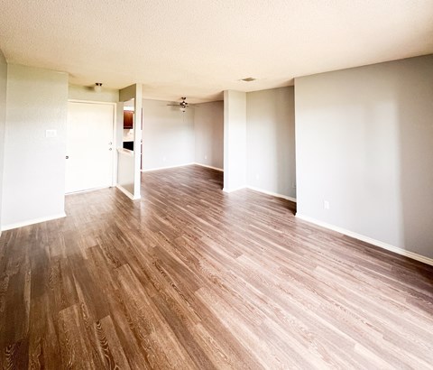 an empty living room with a hard wood floor in Dallas, TX, 75216