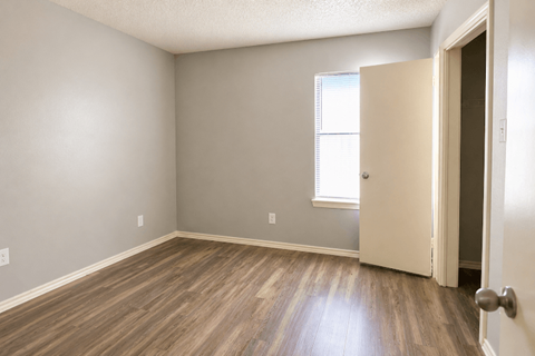 A room with a wooden floor and a white door.