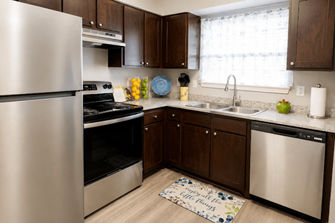 A kitchen with a stainless steel refrigerator, oven, and sink.
