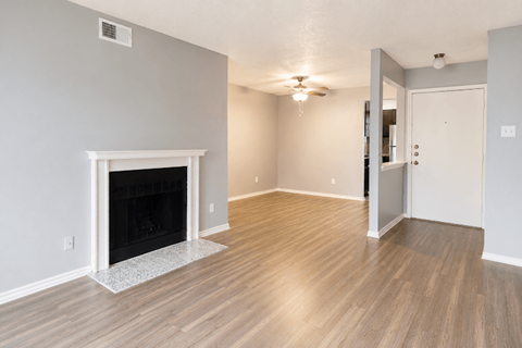 A room with a fireplace and wooden flooring.