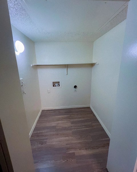 a room with a wood floor and white walls and a white shelf in Dallas, TX, 75216