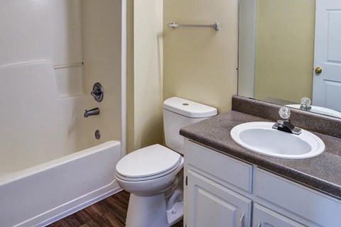 A white toilet sits next to a bathtub in a bathroom.