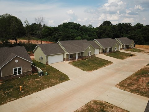A row of houses with driveways in front of them.