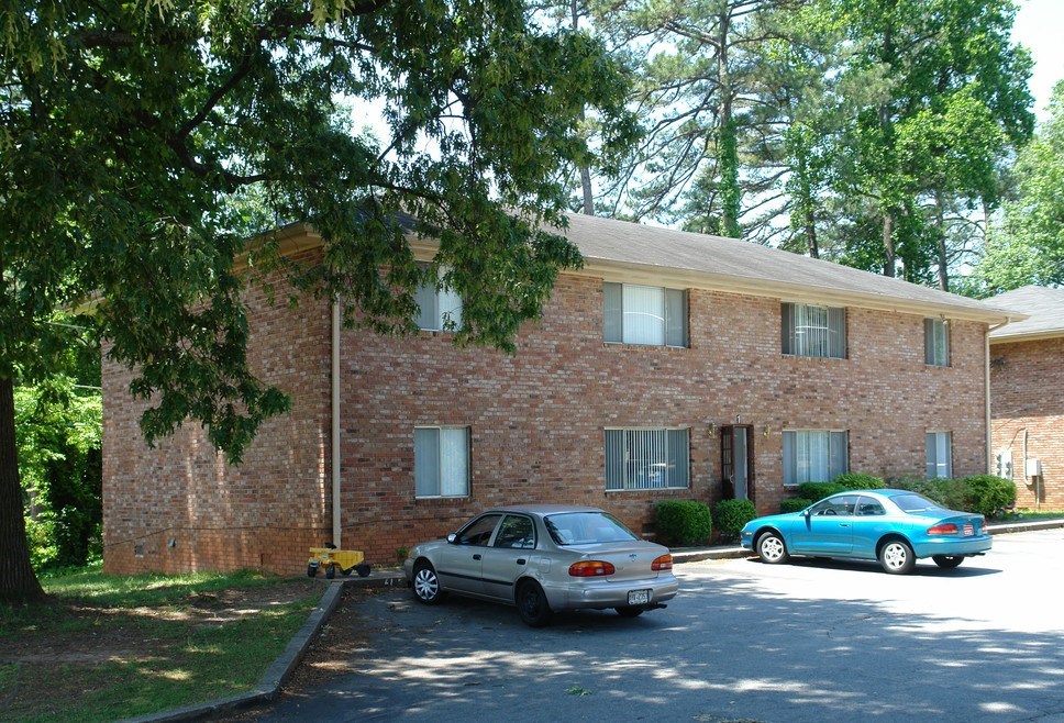 Two cars parked in front of a brick building.