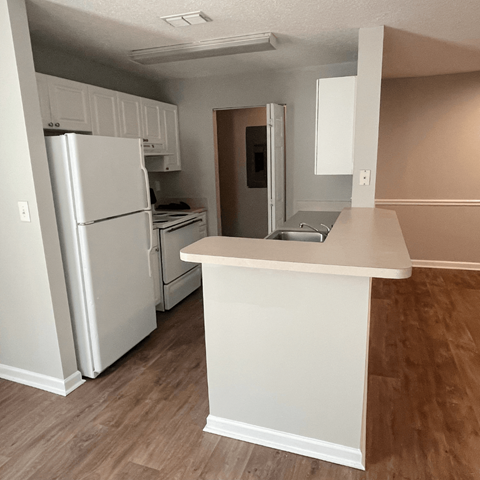 a kitchen with a white counter top and a refrigerator