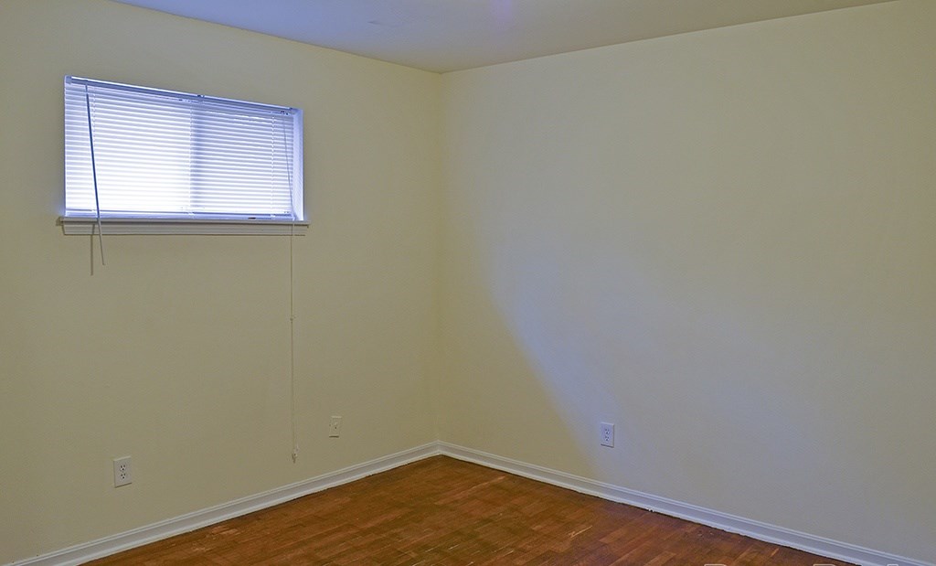 A room with a window and wooden floors.