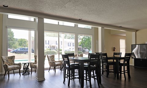 A dining room with a table and chairs.