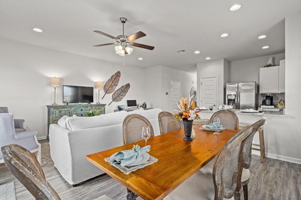 a living room and dining room with a wooden table