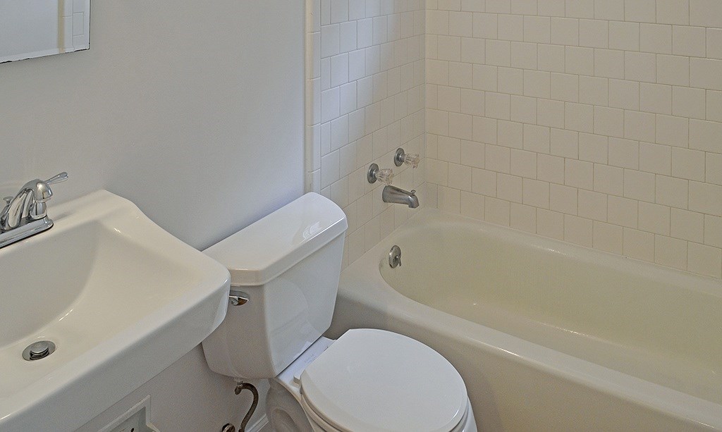 A white toilet sits next to a sink in a bathroom.