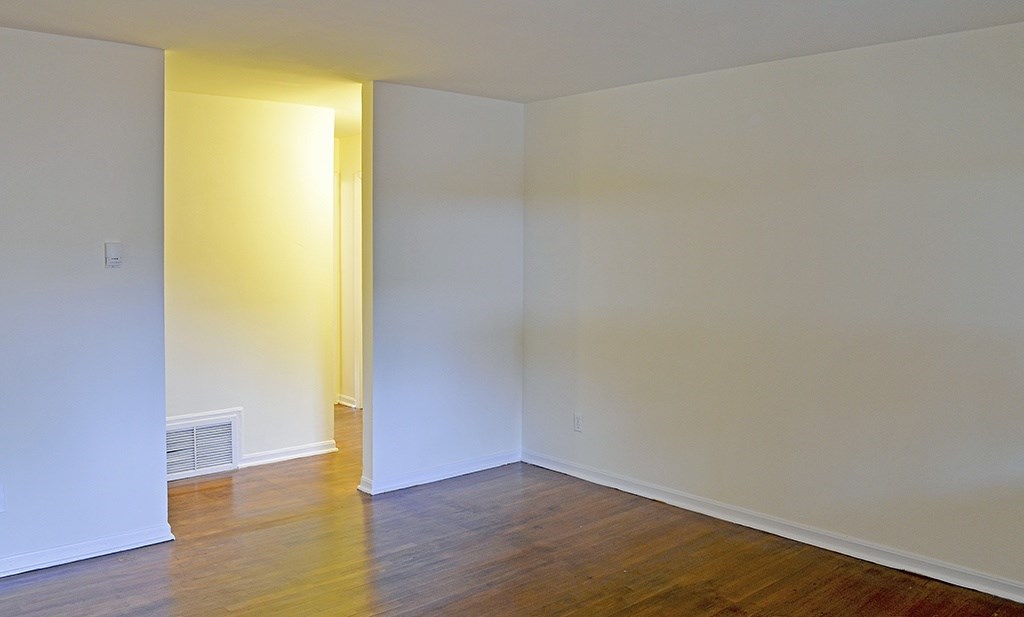A room with a wooden floor and white walls.