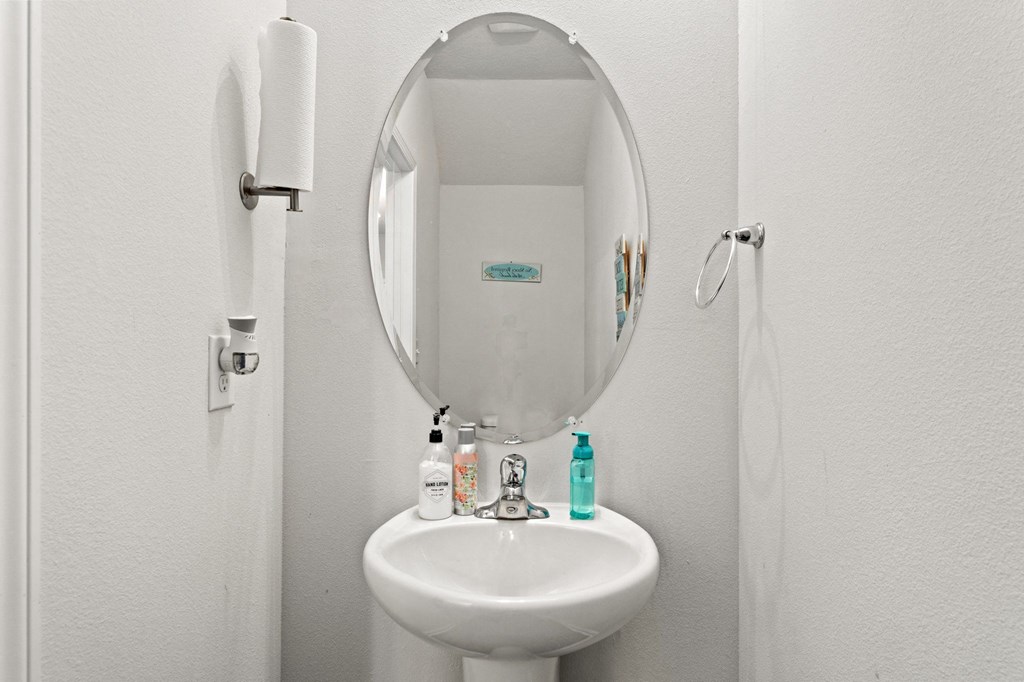 a white bathroom with a sink and a mirror