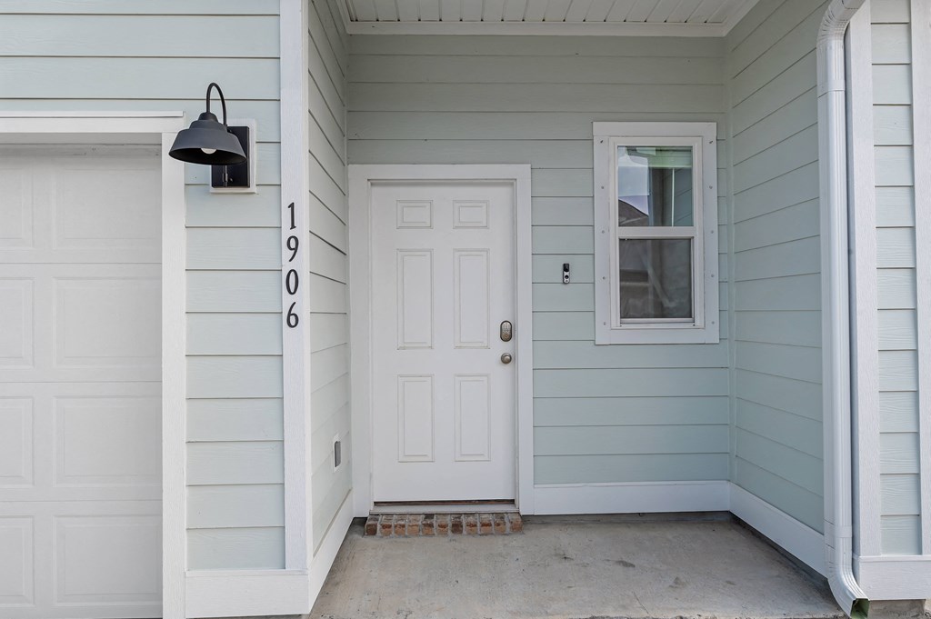 a front porch with a white door and a window
