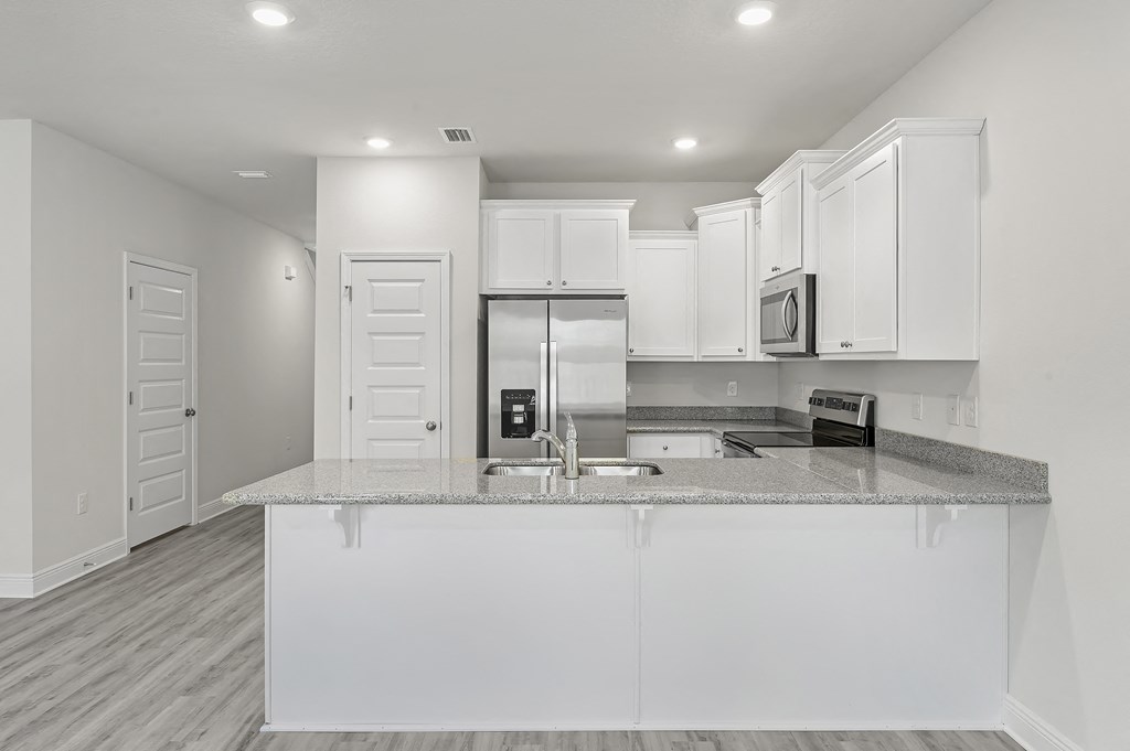 a kitchen with white cabinets and a granite counter top