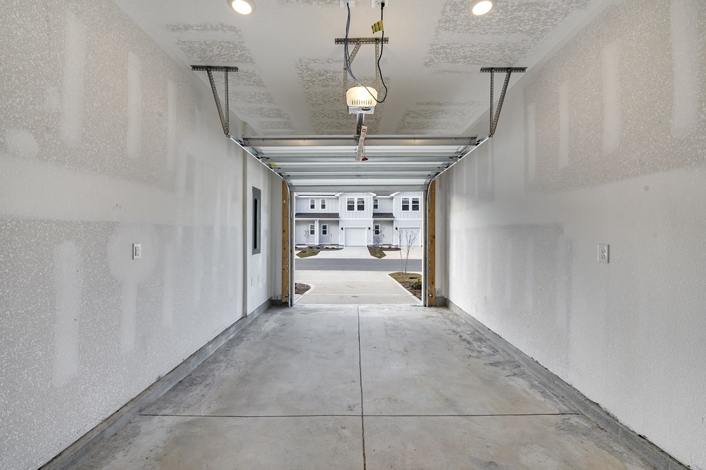 a view down a long corridor with white walls and a light fixture hanging from the ceiling