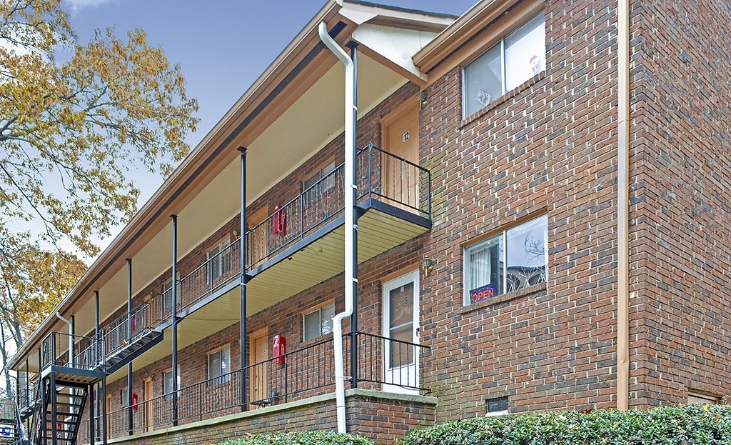 A red brick building with a balcony and a staircase.