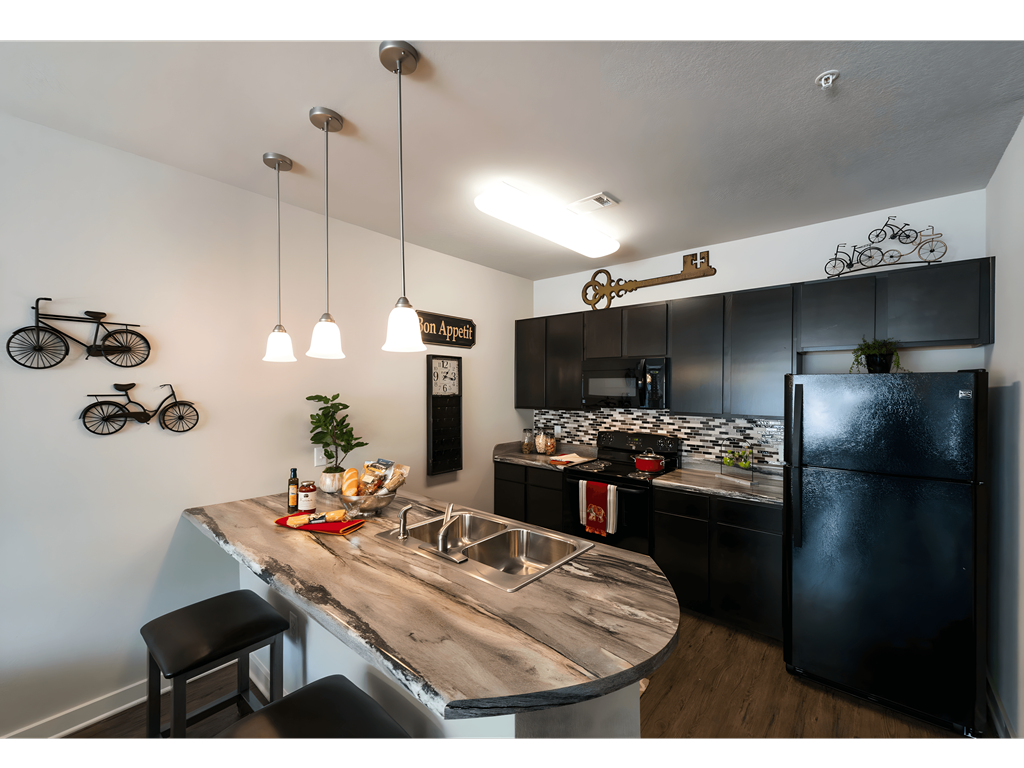 a kitchen with black appliances and a wooden counter top