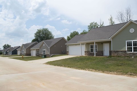 A row of houses with a driveway in front.