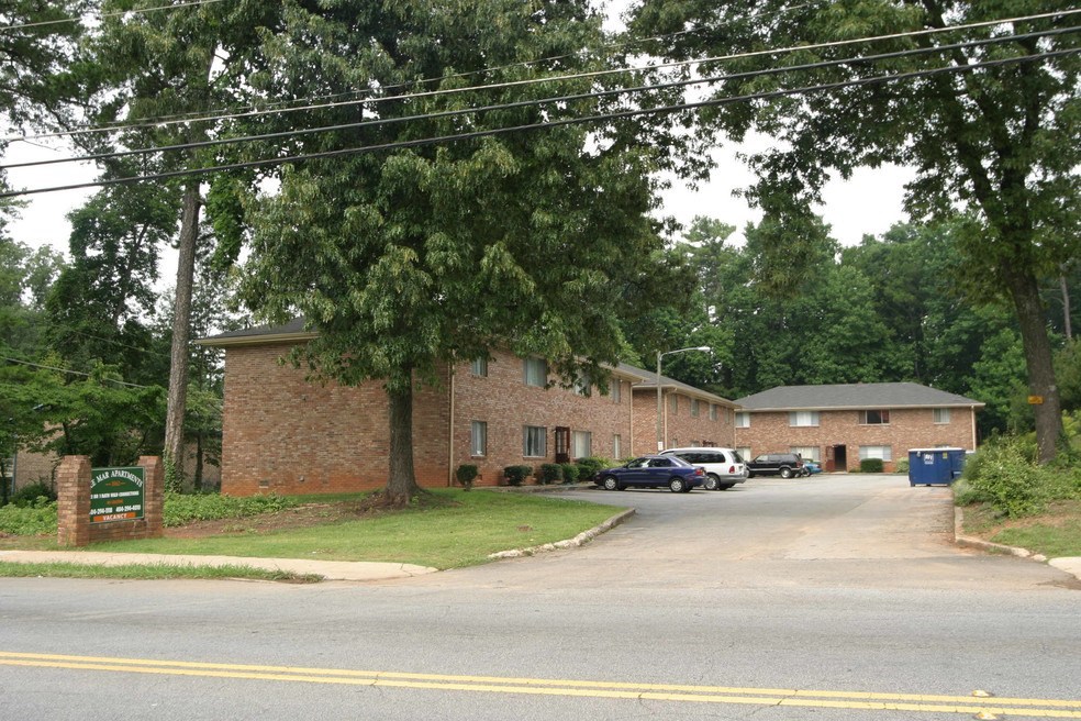 A brick building with a green sign in front of it.