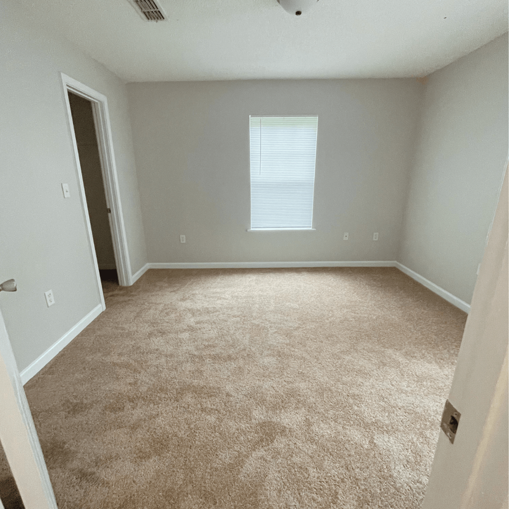 an empty room with a window and a door