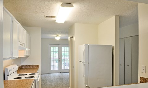 A kitchen with white cabinets and a white stove top oven.