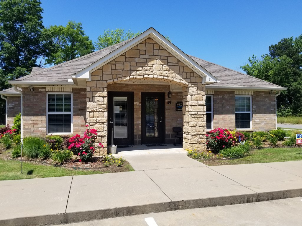 a house with a stone facade and a concrete sidewalk in front of it