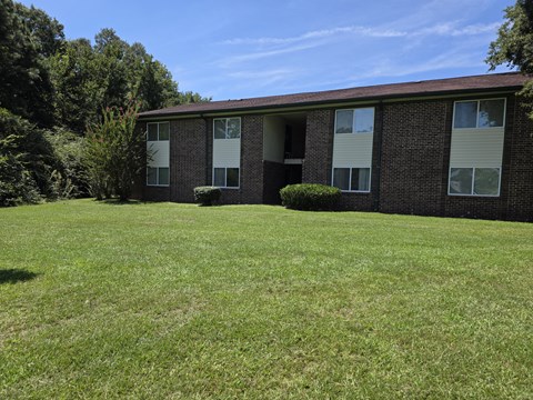 A grassy area in front of a brick building.