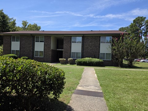 A brick building with a walkway in front.