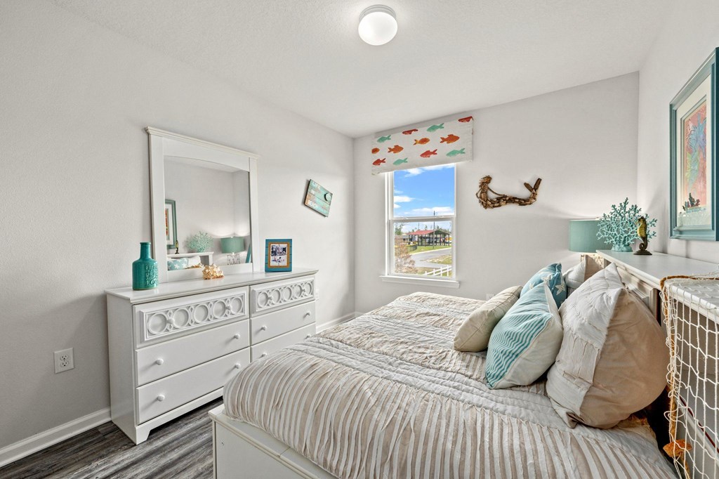 a bedroom with a bed and a dresser and a window