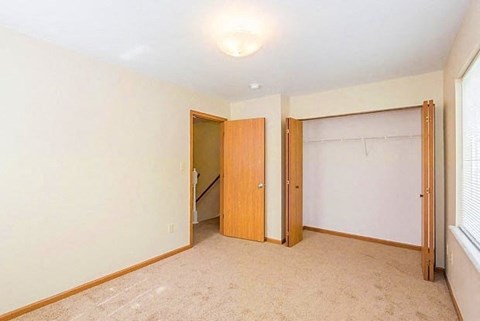 a bedroom with two doors and a window