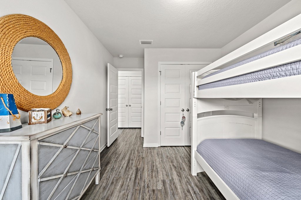 a bedroom with bunk beds and a mirror