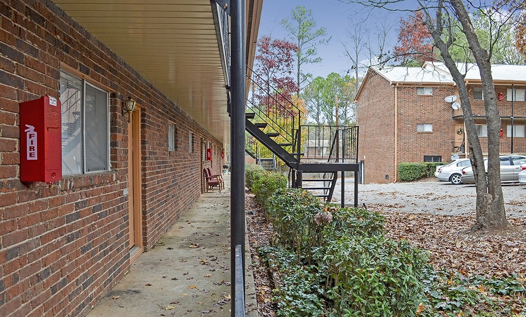 A red fire extinguisher is mounted on a brick wall.