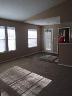 A room with a carpeted floor and a door.