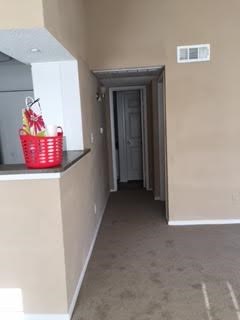 A hallway with a red basket on the counter.