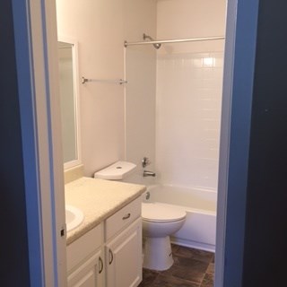 A white toilet sits in a bathroom next to a sink.