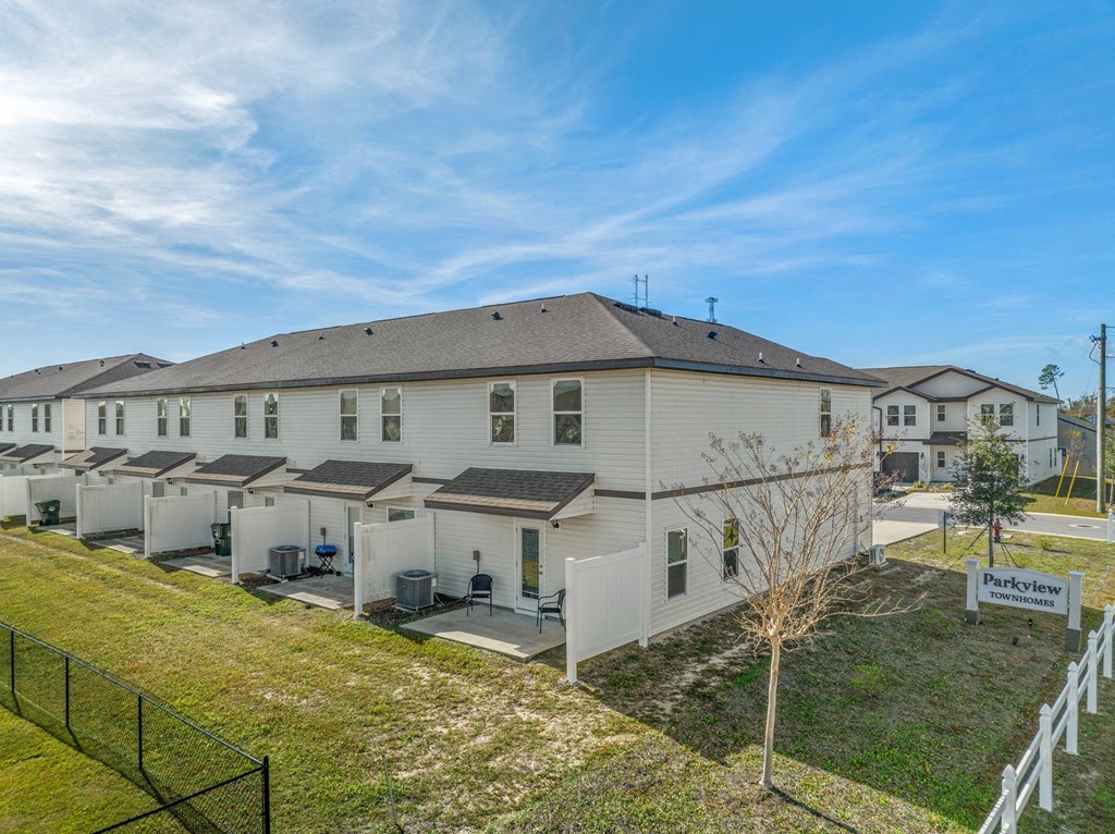 a row of white houses with solar panels on the roof