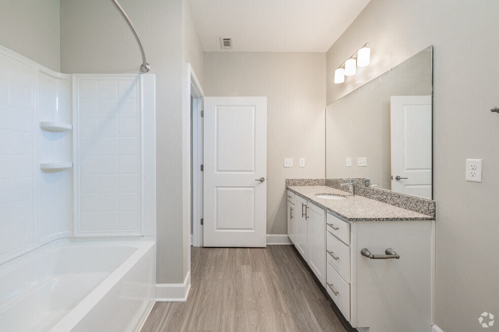 a bathroom with a shower and a sink and a mirror