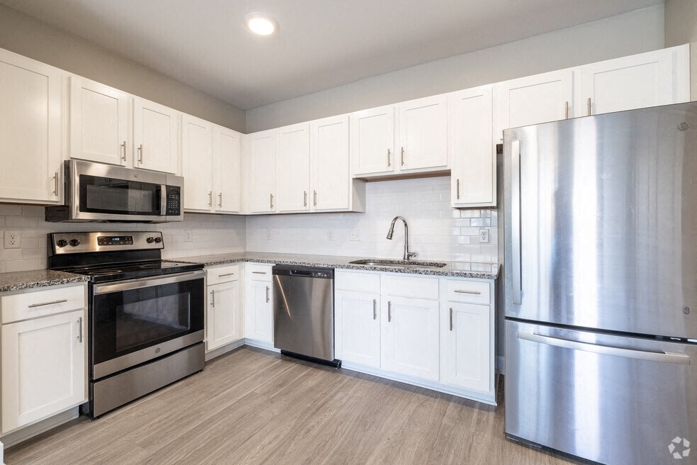 a kitchen with stainless steel appliances and white cabinets