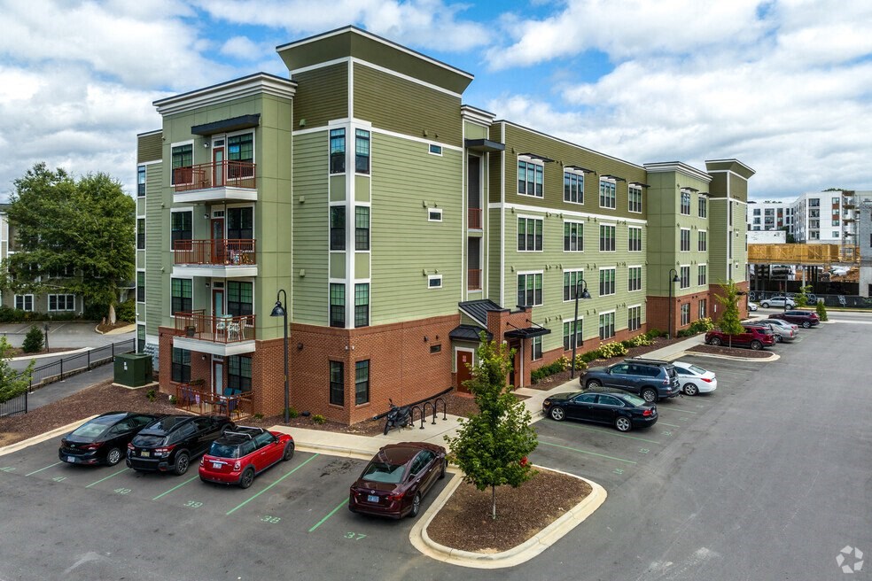 a large apartment building with cars parked in a parking lot