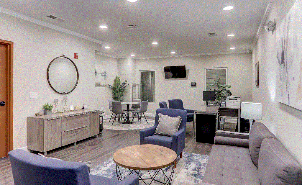 a living room with couches and chairs and a table and a desk