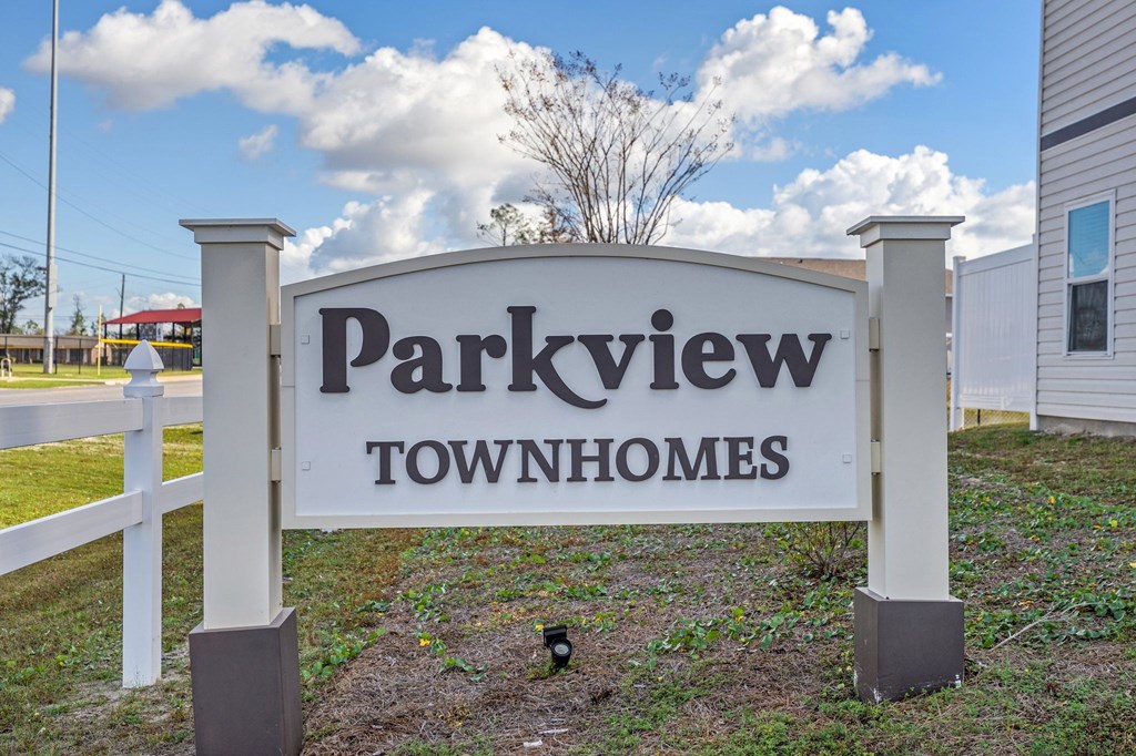 a parkview town homes sign in front of a white fence