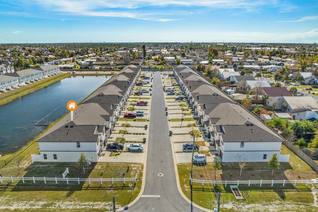 an aerial view of a neighborhood with houses and a body of water