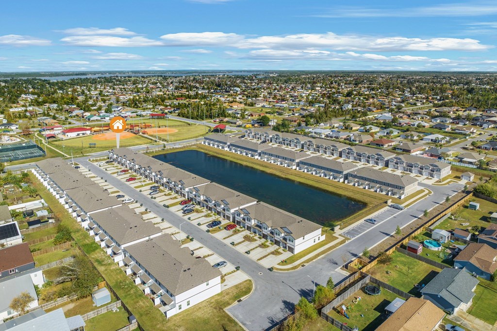 an aerial view of a parking lot and a body of water
