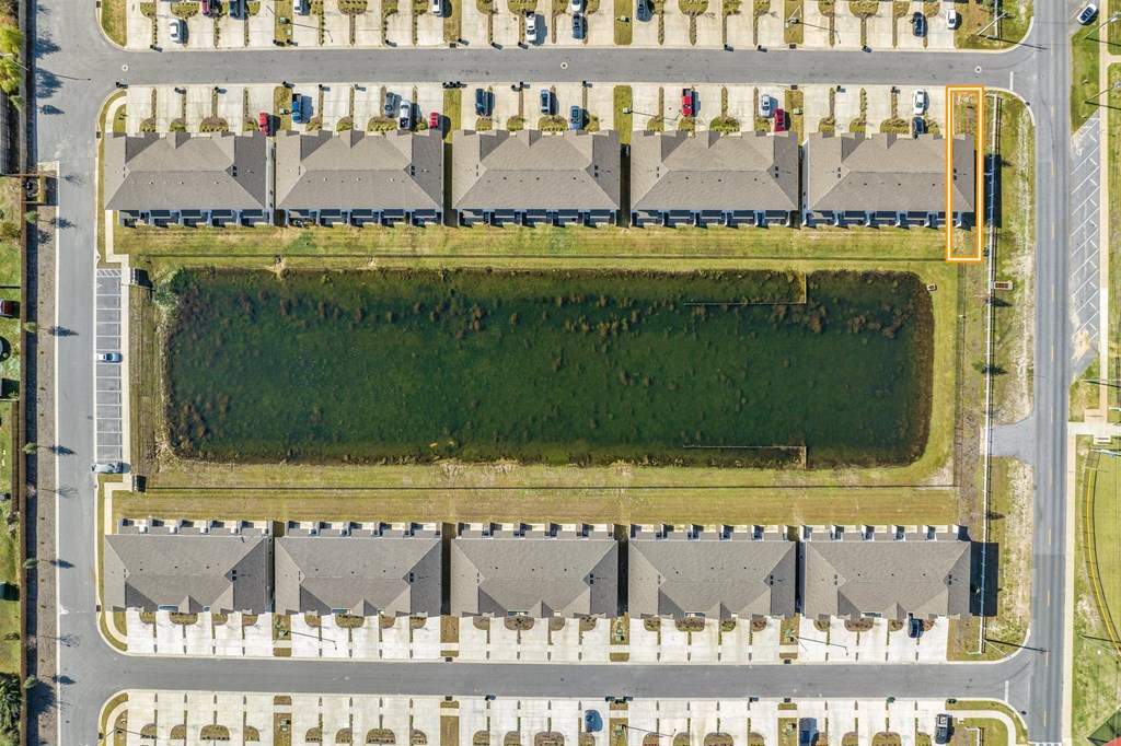 an aerial view of a parking lot with cars and a field