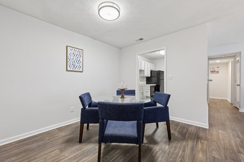 A dining room with a table and chairs.