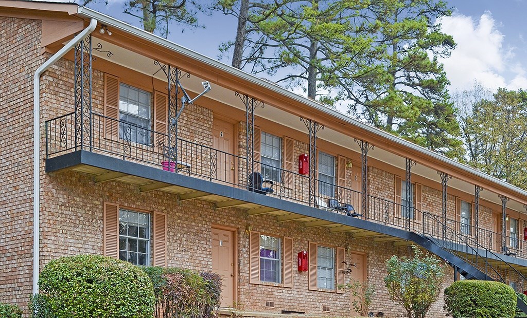 A red brick building with a balcony and a staircase.