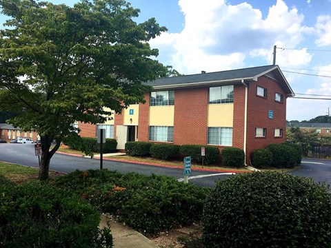 A red brick building with a tree in front of it.