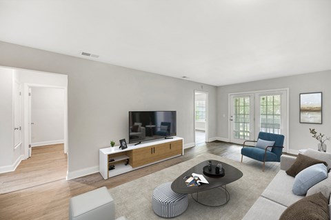 A modern living room with a television, a sofa, and a coffee table.