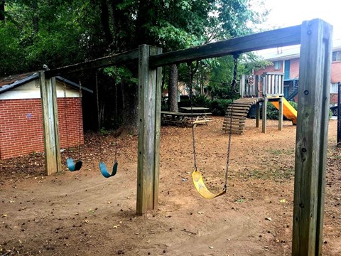 A playground with a swing set and a slide.