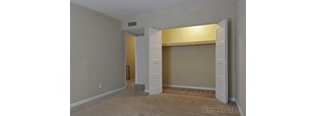 A room with a white door and a carpeted floor.